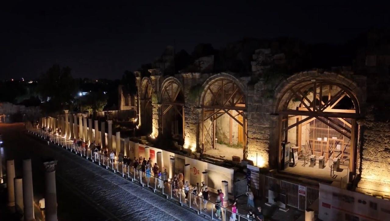 Tourists walk along the illuminated pathways of the Side Archaeological Site during evening hours. (AA Photo)