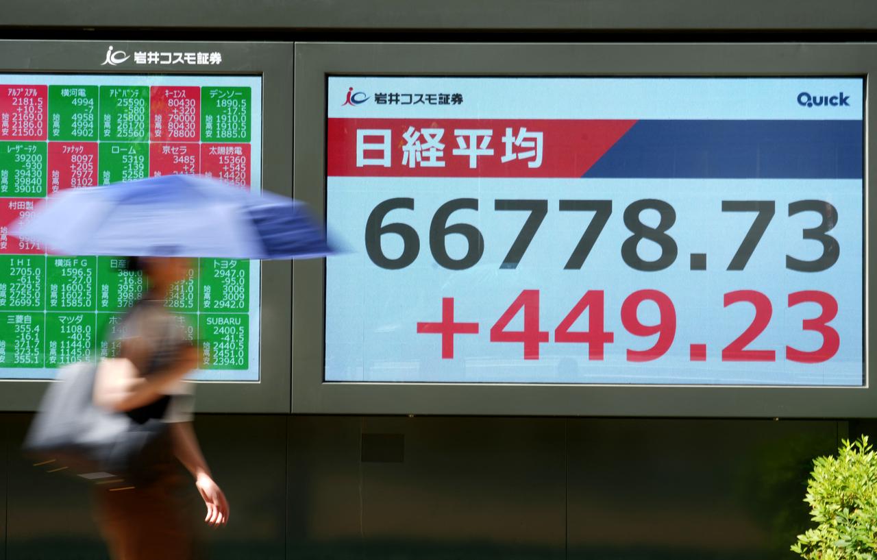 A woman walks past an electronic quotation board displaying the Nikkei Stock Average on the Tokyo Stock Exchange along a street in Tokyo, June 1, 2026. (AFP Photo)