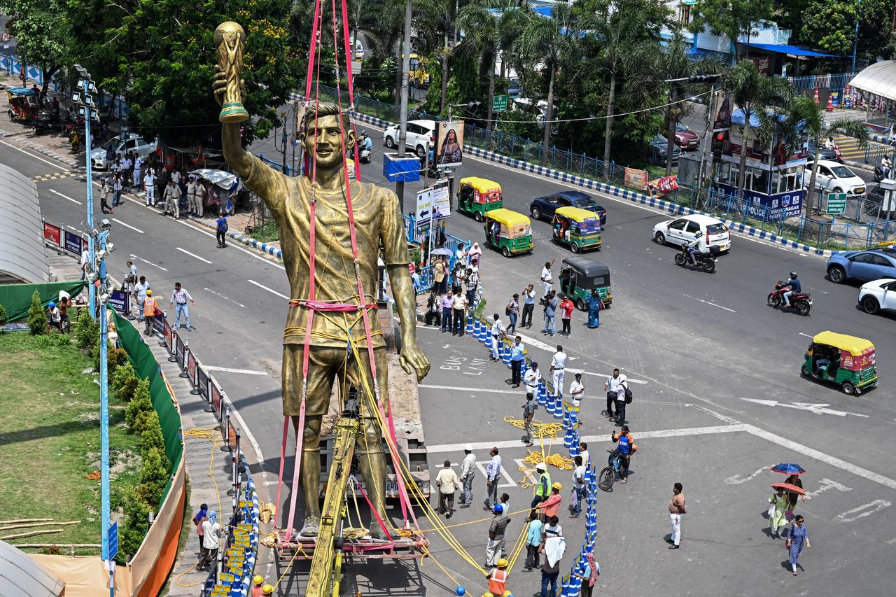 Pedestrians watch as workers remove a statue of Argentine football player Lionel Messi, June 1, 2026. (AFP Photo)