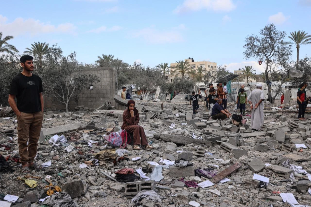 Palestinians look at the damage at the site of a residential building targeted overnight by an Israeli strike, following a warning from the Israeli military to evacuate, in Deir el-Balah, central Gaza Strip, May 24, 2026. (AFP Photo)