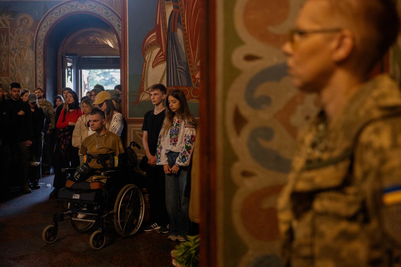 Mourners pay tribute next to the coffin of Yaroslav Varnak, 23 years old, a serviceman who was killed in action, during his funeral ceremony in Kyiv on June 8, 2026, amid the Russian invasion of Ukraine. ( AFP Photo)