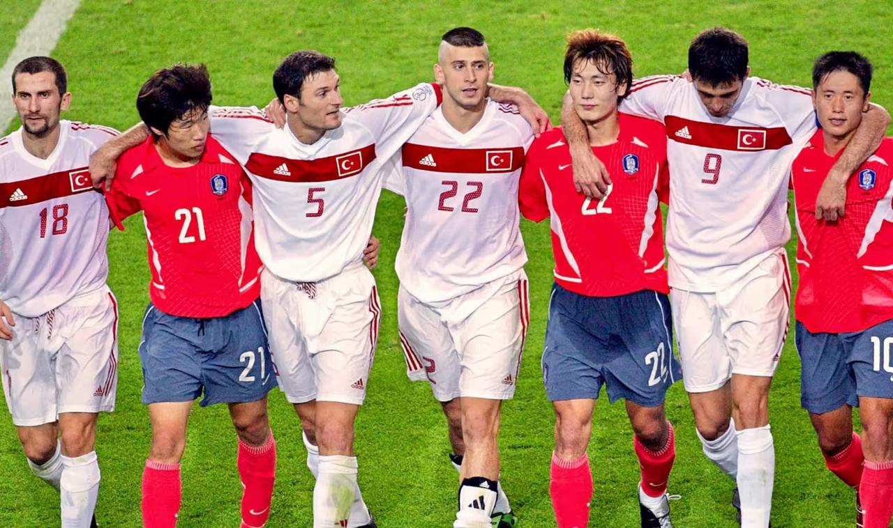 Turkish and South Korean players walk together after Türkiye’s 3-2 win in the third-place match at the 2002 FIFA World Cup. (Photo via FIFA)