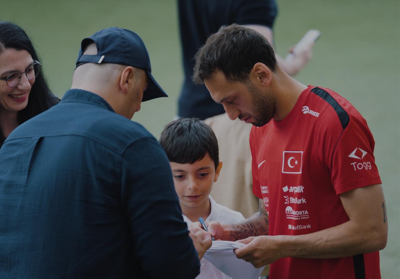 Türkiye captain Hakan Calhanoglu signs an autograph for a young fan during national team preparations. (AA Photo)