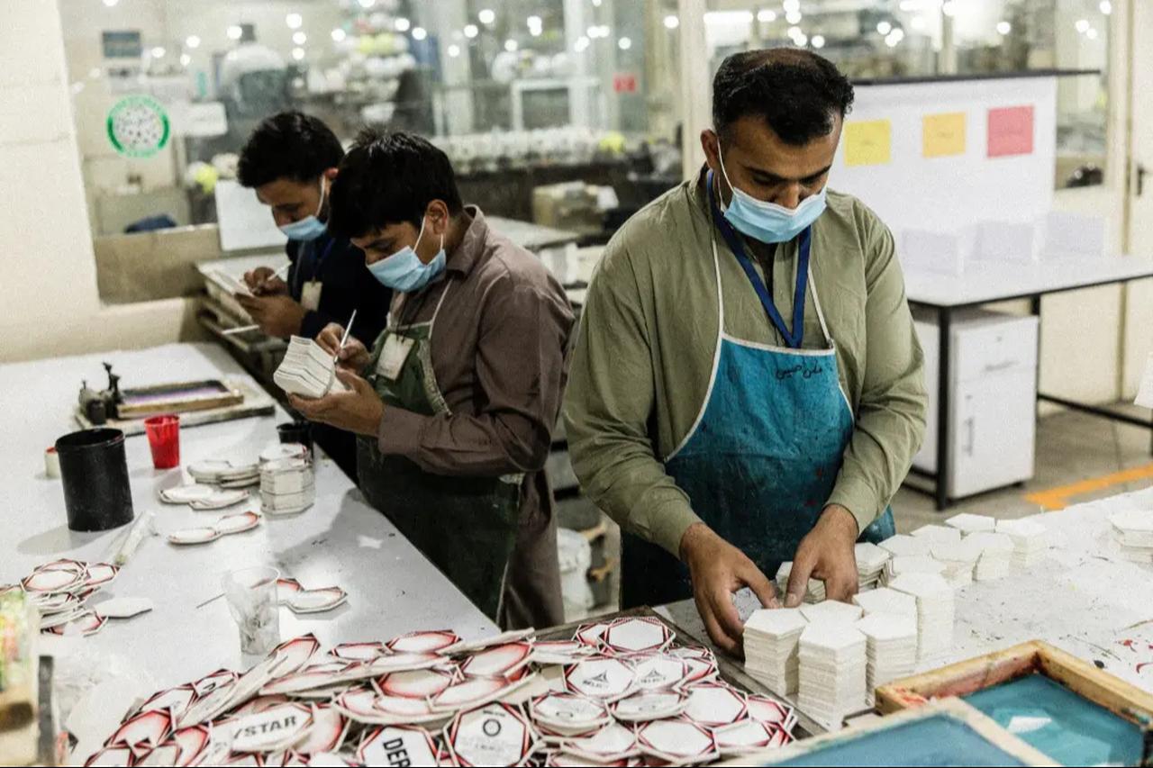Workers in a factory in Sialkot, Pakistan, hand-applying colors and logos to individual panels that will make up a football. (Photo via Stefan Bohrer/SWNS)