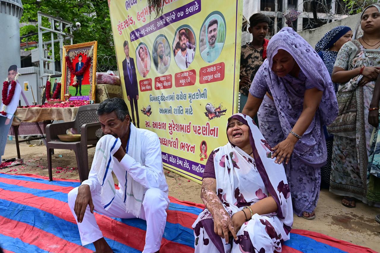 The mother (bottom R) of Air India Flight 171 plane crash victim Akash Patni grieves at the crash site on the first anniversary of the disaster in Ahmedabad on June 12, 2026. (AFP Photo)