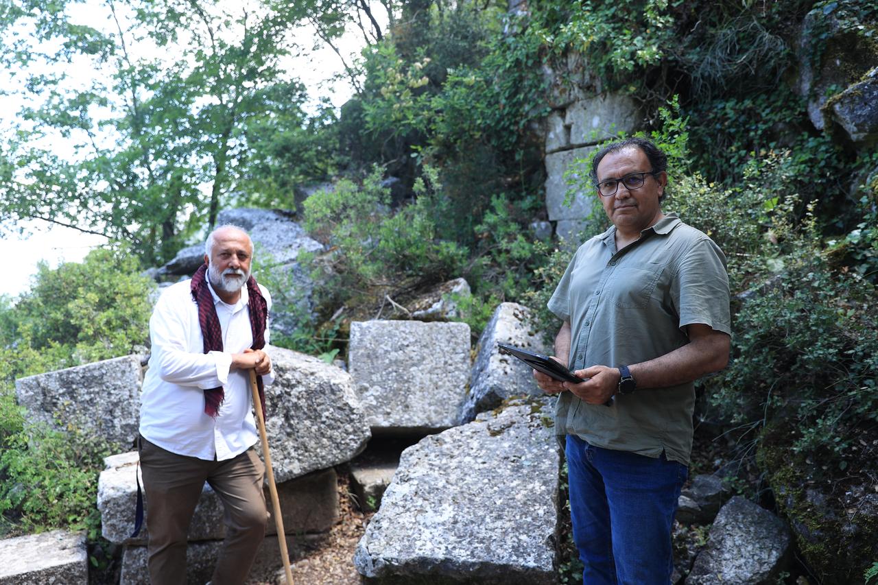 Researchers examine inscribed blocks near the collapsed gate of ancient Termessos in Antalya, southern Türkiye. (AA Photo)