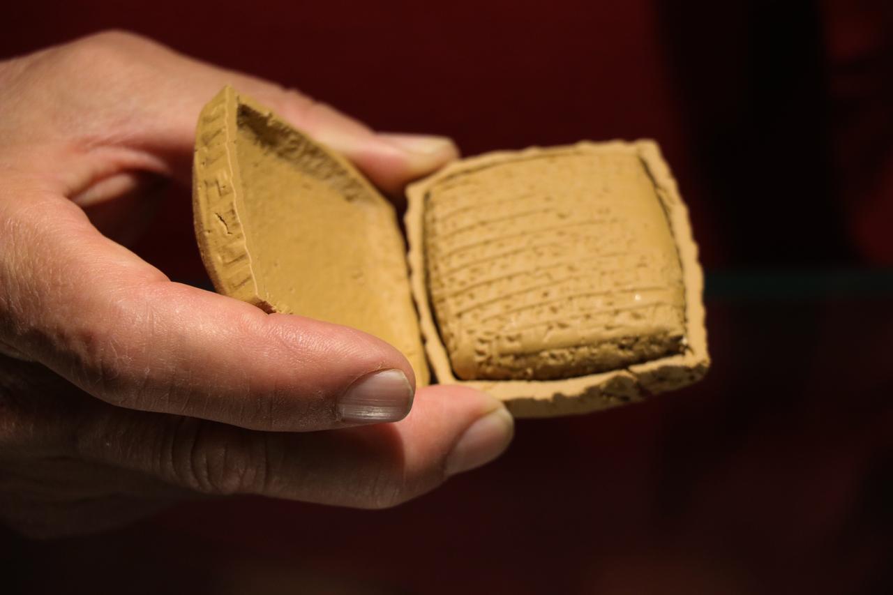 Professor Fikri Kulakoglu shows a replica example of a clay tablet sealed in a mud envelope at Kayseri Archaeology Museum, Türkiye, June 12, 2026. (AA Photo)