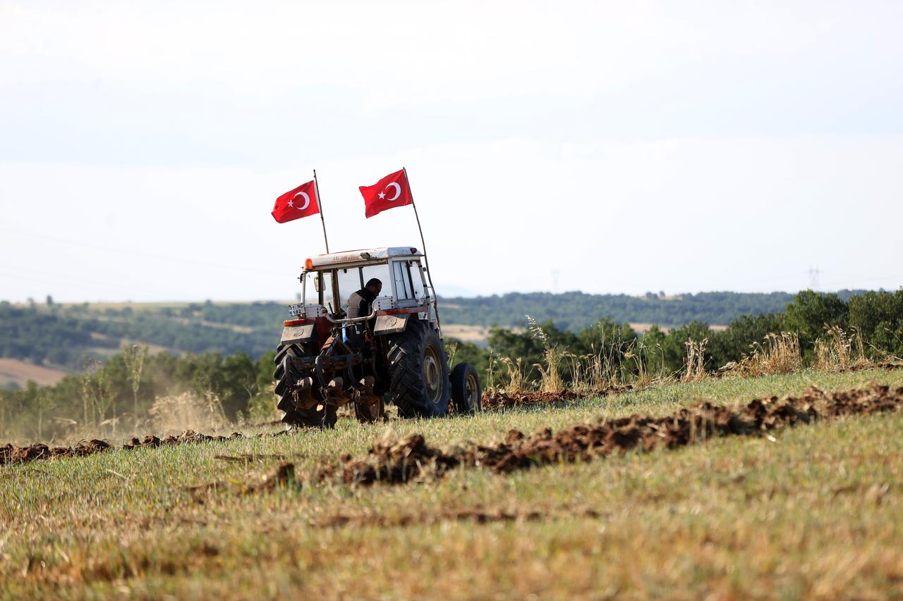 Farmer Burak Tunckol drives a tractor decorated with Turkish flags after carving a World Cup support message into his field, in Kirklareli, western Türkiye, June 12, 2026. (AA Photo)