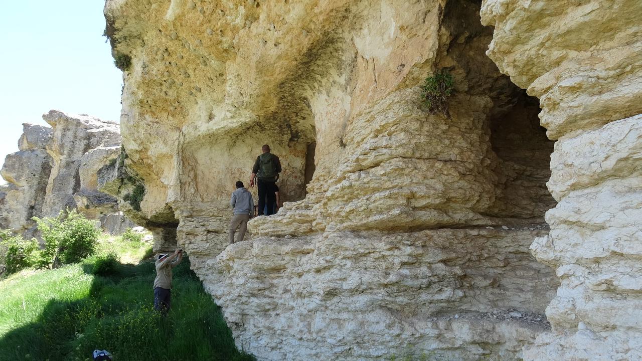 Researchers examine the entrance and rock surfaces of the newly discovered prehistoric painted cave in Malatya's Tohma Canyon, eastern Türkiye. (IHA Photo)