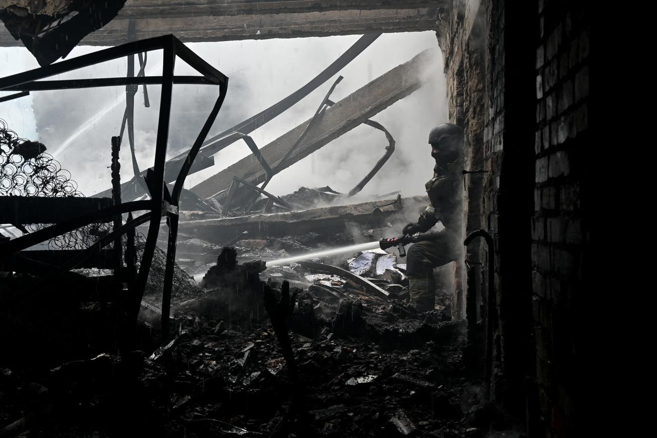 A Ukrainian rescuer works to extinguish a fire in a building following an air attack in Kharkiv on June 10, 2026, amid the Russian invasion of Ukraine. (AFP Photo)