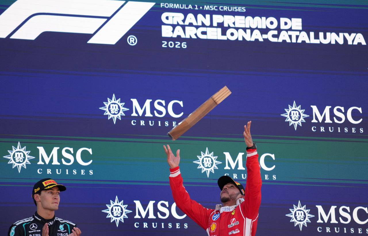 Winner Ferrari's British driver Lewis Hamilton celebrates on the podium next to Mercedes' British driver George Russell (L) after the Catalonia Formula One Grand Prix at the Circuit de Catalunya in Montmelo, on the outskirts of Barcelona, on June 14, 2026. (AFP Photo)