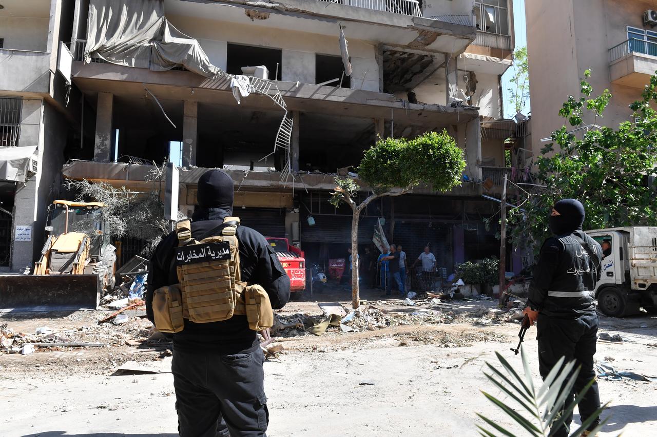 Members of security forces and onlookers gather near a heavily damaged building following an Israeli airstrike on the Dahieh district in Beirut, Lebanon, June 14, 2026. (AA Photo)