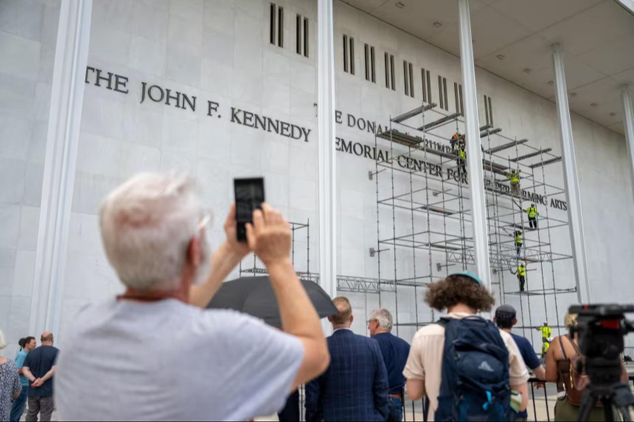 People stop to watch workers erect scaffolding at the Kennedy Center in Washington DC, US. (Photo via Daniel Heuer/Bloomberg)