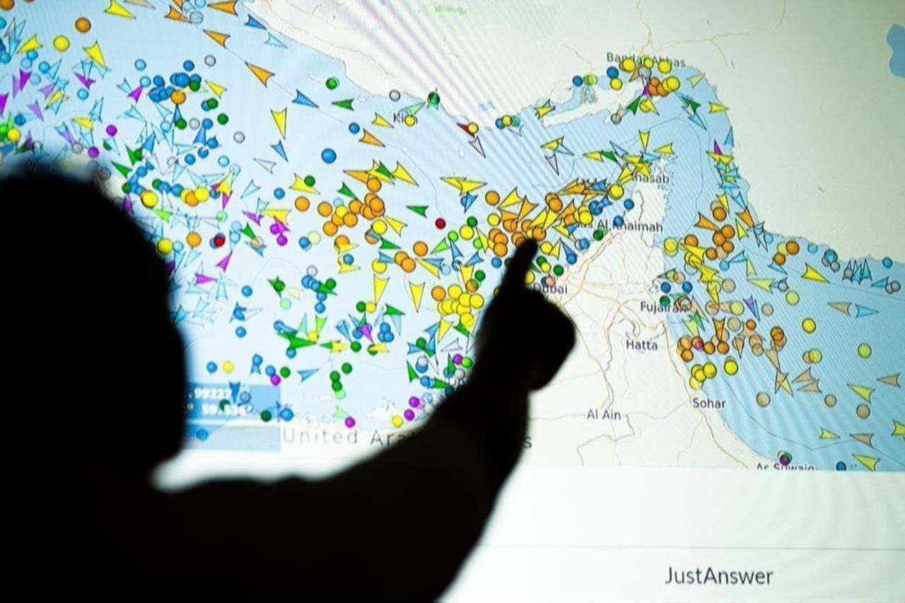 A photo illustration taken in Lefkosia on May 4, 2026, shows a person in front of a large screen displaying vessel movements in the Strait of Hormuz on a ship-tracking website. (AFP Photo)