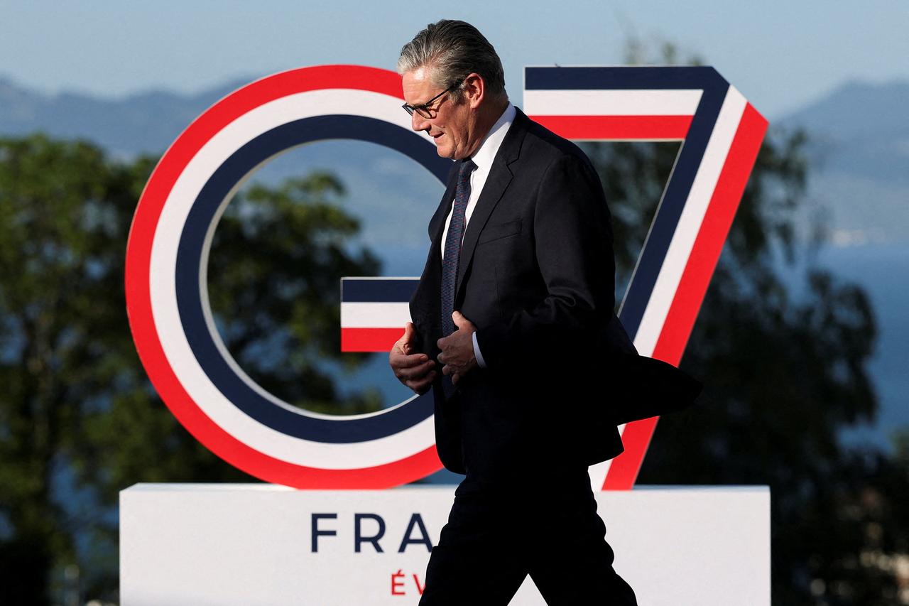 Britain's Prime Minister Keir Starmer walks past the G7 logo during the official greeting as part of the G7 summit, in Evian, eastern France, June 15, 2026. (AFP Photo)