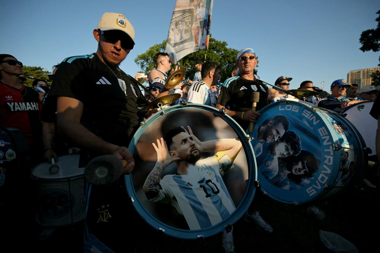 An Argentine supporter hits a bass drum depicting Argentine football player Lionel Messi as he takes part in a "banderazo" flag-waving gathering at Mill Creek Park in Kansas City on June 15, 2026, during the 2026 World Cup football tournament. (AFP Photo)