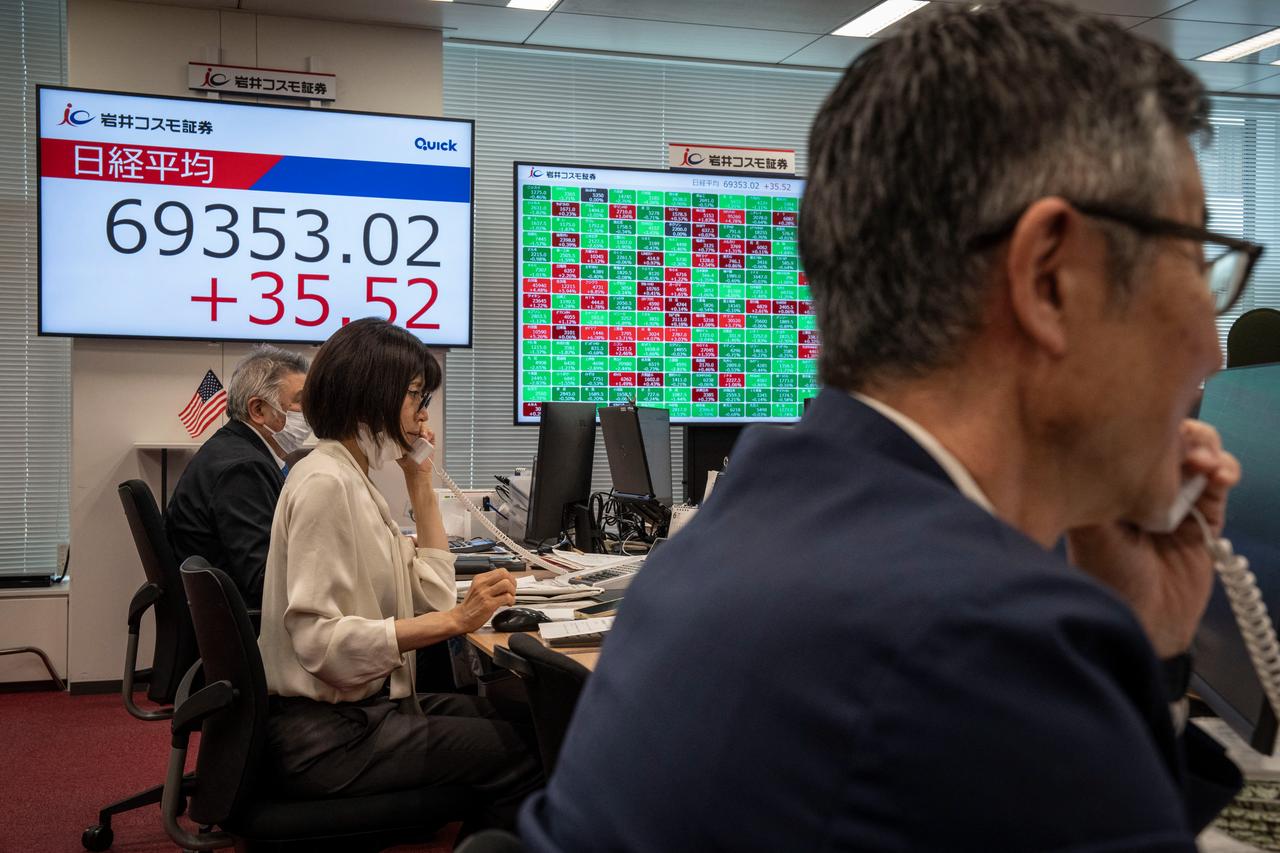 Members of a securities firm work in front of a screen displaying the Nikkei Stock Average on the Tokyo Stock Exchange in Tokyo, June 16, 2026. (AFP Photo)