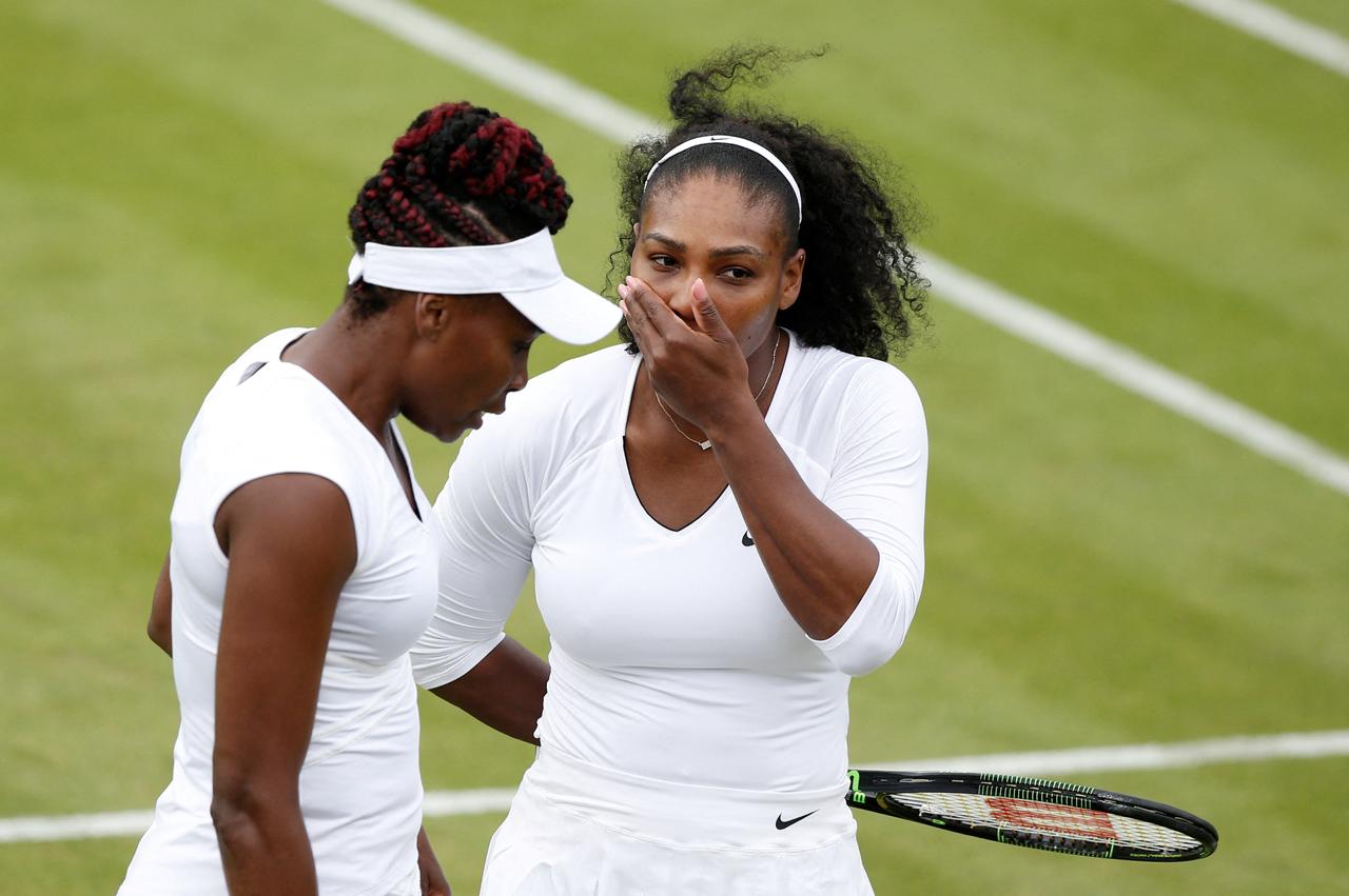 US player Serena Williams (R) and her partner US player Venus Williams (L) talk between points against Slovenia's Andreja Klepac and Katarina Srebotnik during their women's doubles first round match on the fourth day of the 2016 Wimbledon Championships at The All England Lawn Tennis Club in Wimbledon, London, England, on June 30, 2016. (AFP Photo)