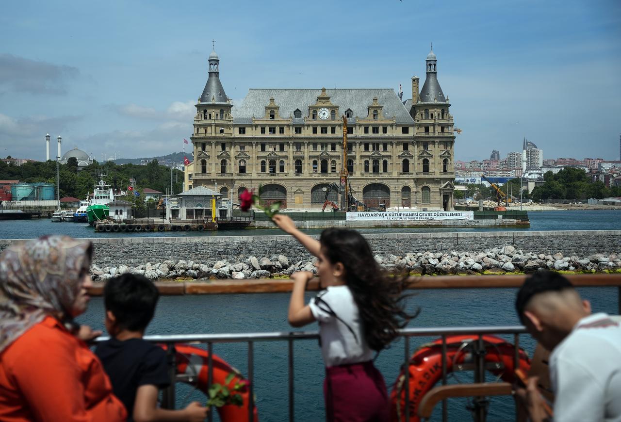 People look out toward Haydarpasa Railway Station from the waterfront as the restored facade of the historic building comes back into view. (IHA Photo)