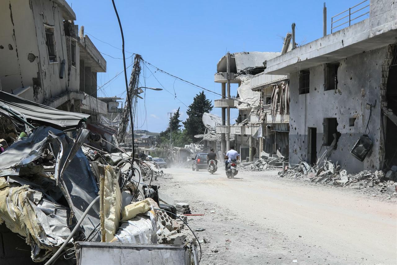 Residents drive past destroyed buildings as they return to the southern village of Srifa, June 16, 2026. (AFP Photo)