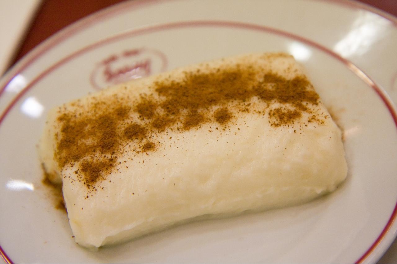 Tavuk gogsu, muhallebi's distinguished cousin, a white milk pudding made with finely shredded chicken breast, served on a plate topped with cinnamon. (Adobe Stock Photo)