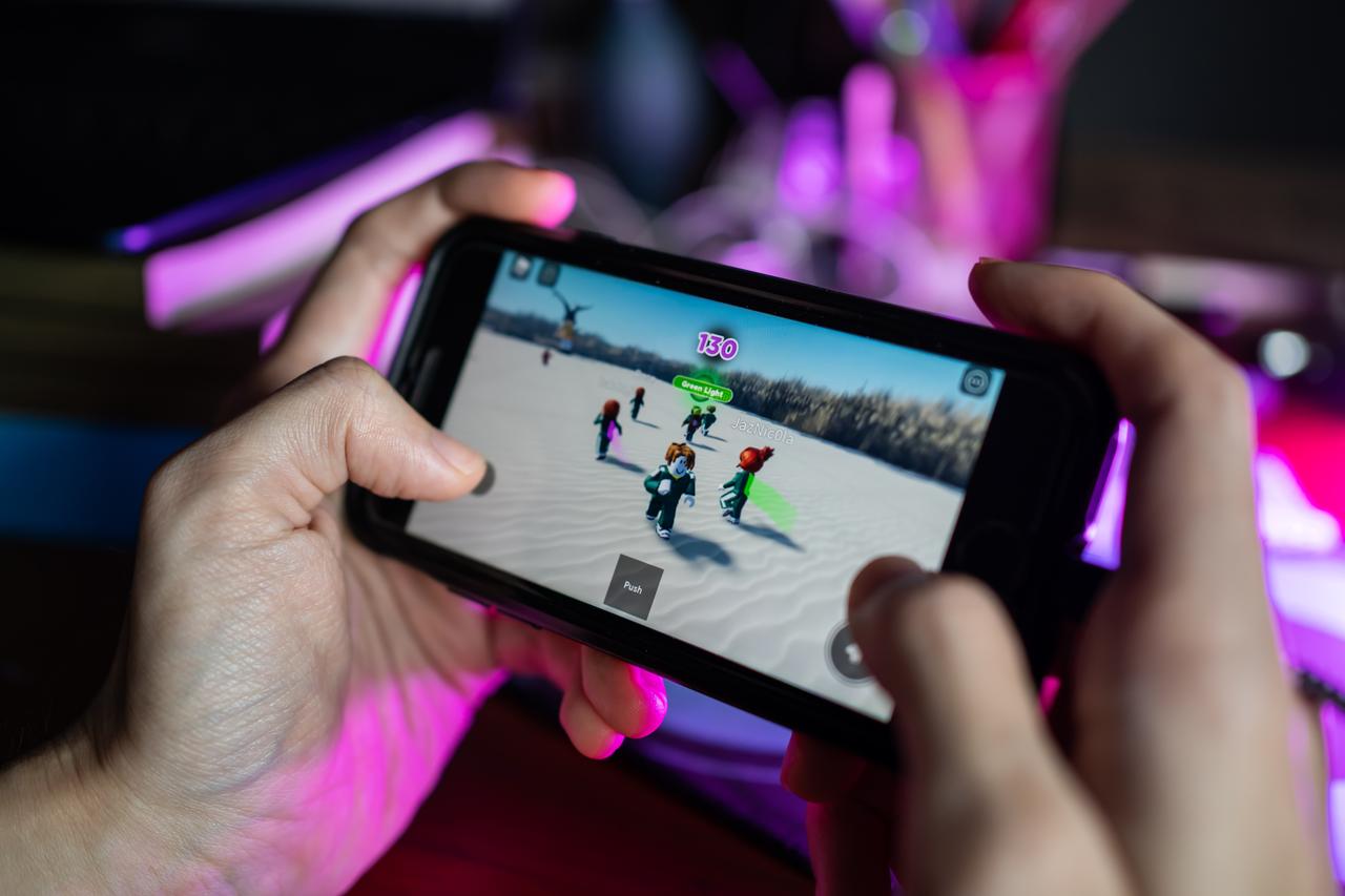 A player uses a smartphone to access Roblox, in this representative image. (Adobe Stock Photo)