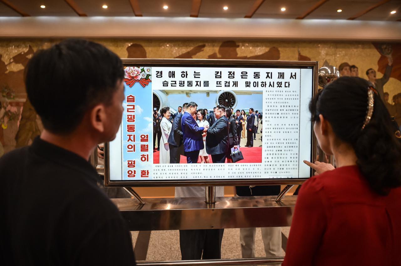 People look at a screen with the newspaper "Rodongsinmun" showing the news on the visit of China's President Xi Jinping, in the Kaeson Station of the Pyongyang Metro in Pyongyang, June 9, 2026. (AFP Photo)