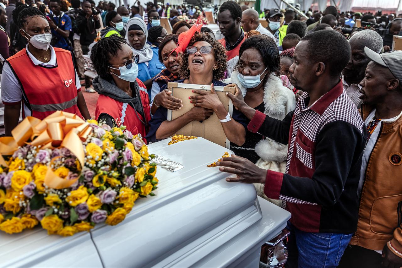 A relative hugs a portrait of a victim of the Utumishi Girls' Academy Senior School fire as she mourns with others during a memorial mass  in Gilgil, Kenya, on June 12, 2026. (AFP Photo)