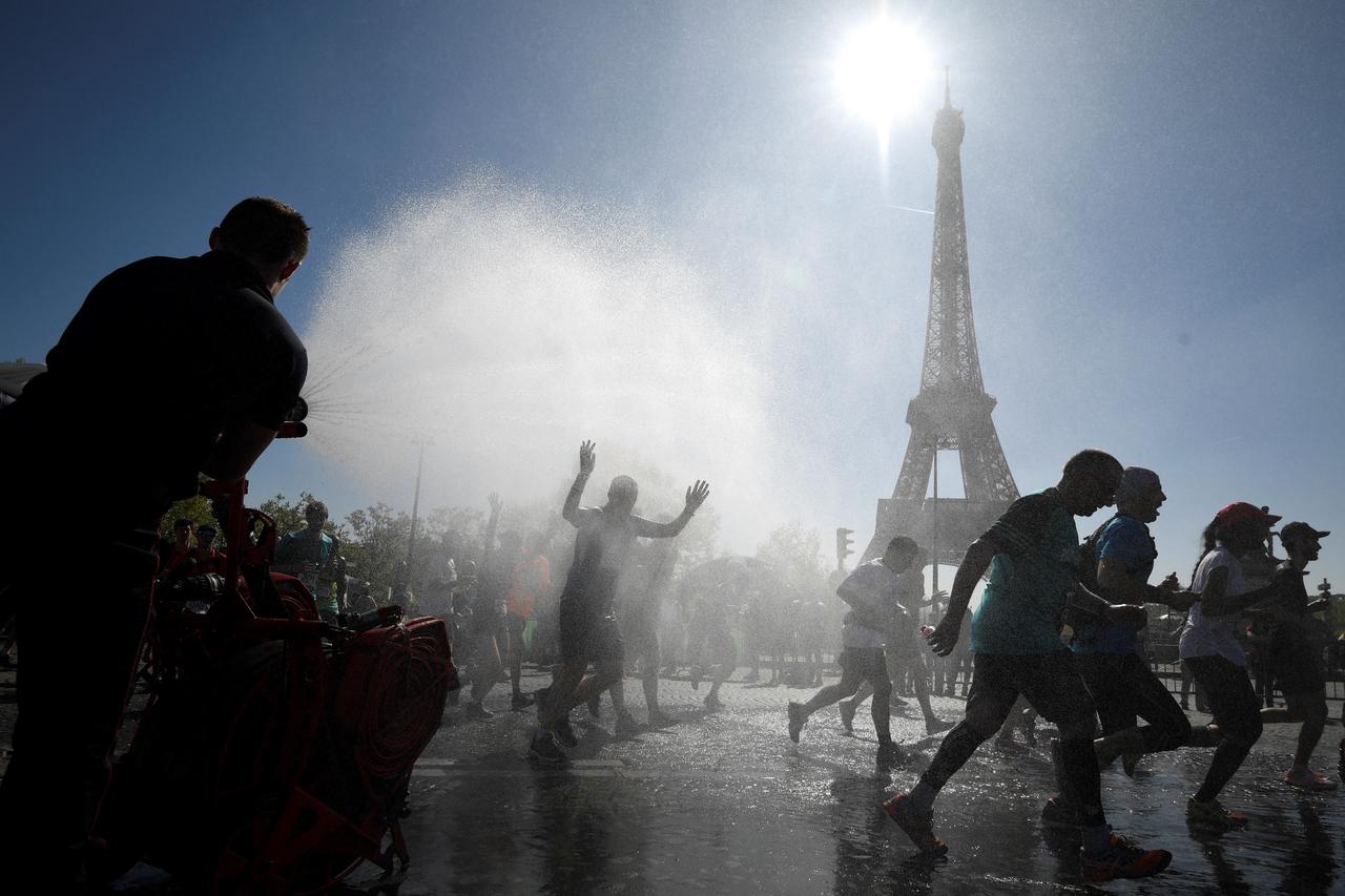 Runners go through a cooling water stream as they compete in the 41st Paris Marathon in front of the Eiffel tower in Paris on April 9, 2017. (AFP Photo)