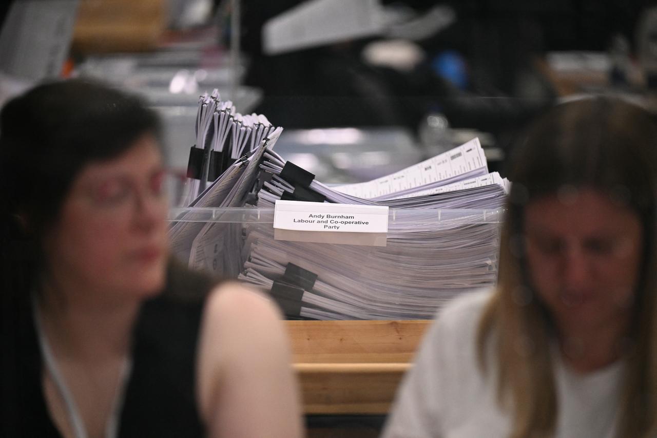 A container full of votes cast for Andy Burnham is seen as electoral staff count votes at the Edge in Wigan, northwest England on June 19, 2026. (AFP Photo)
