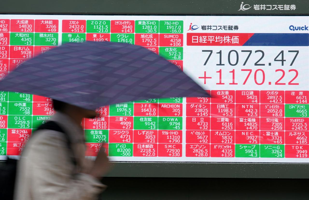 A man walks past an electronic quotation board displaying the Nikkei Stock Average on the Tokyo Stock Exchange in Tokyo, June 18, 2026. (AFP Photo)