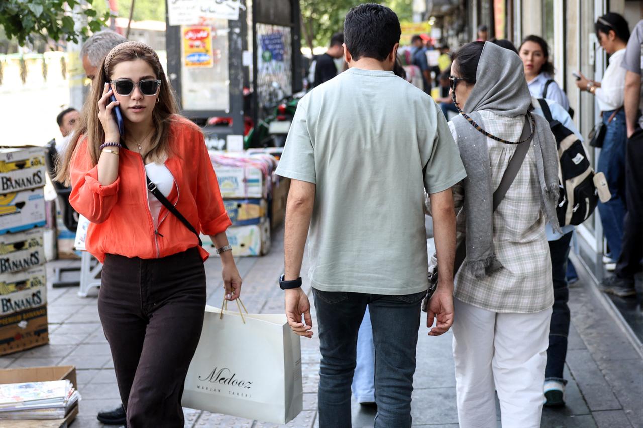 Iranians walk through a street in Tehran on June 18, 2026. The United States and Iran have signed a deal to end the Middle East war. (AFP Photo)