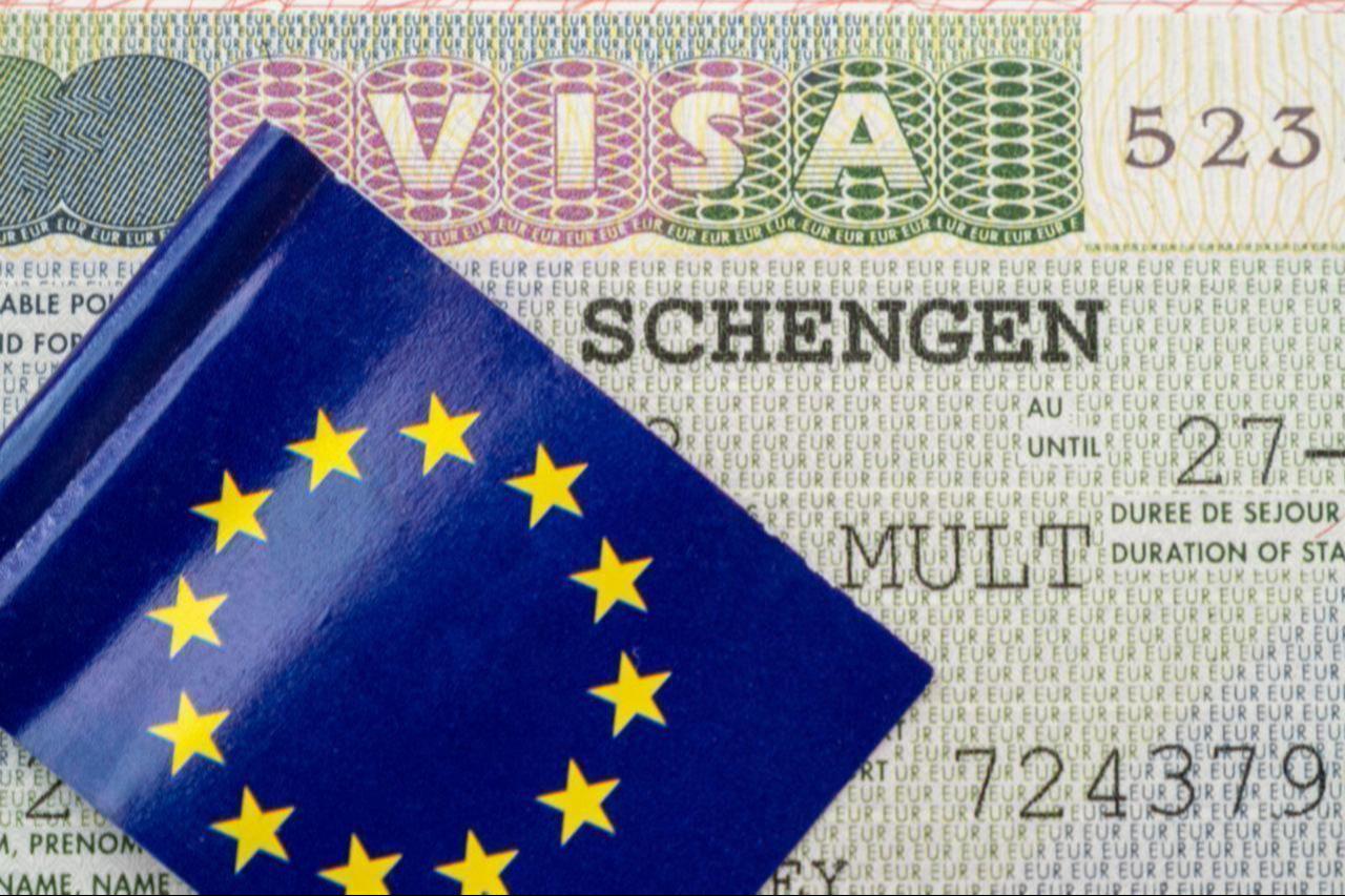 A close-up of a Schengen visa with the flag of the EU on top, date and time undisclosed. (Adobe Stock Photo)