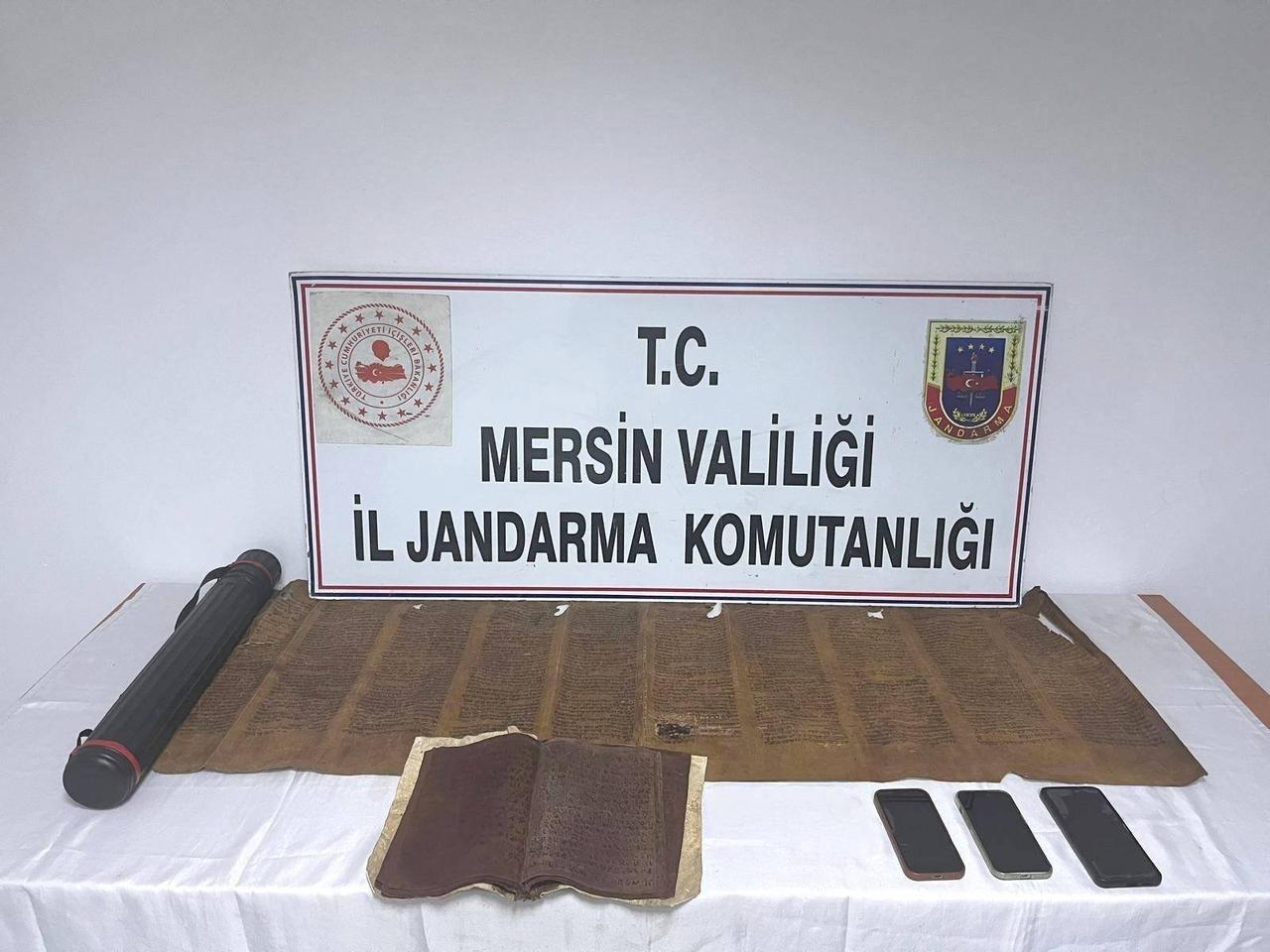 A Torah, a handwritten leather panel and mobile phones seized during an anti-smuggling operation in Tarsus, Mersin, Türkiye, May 5, 2026. (IHA Photo)