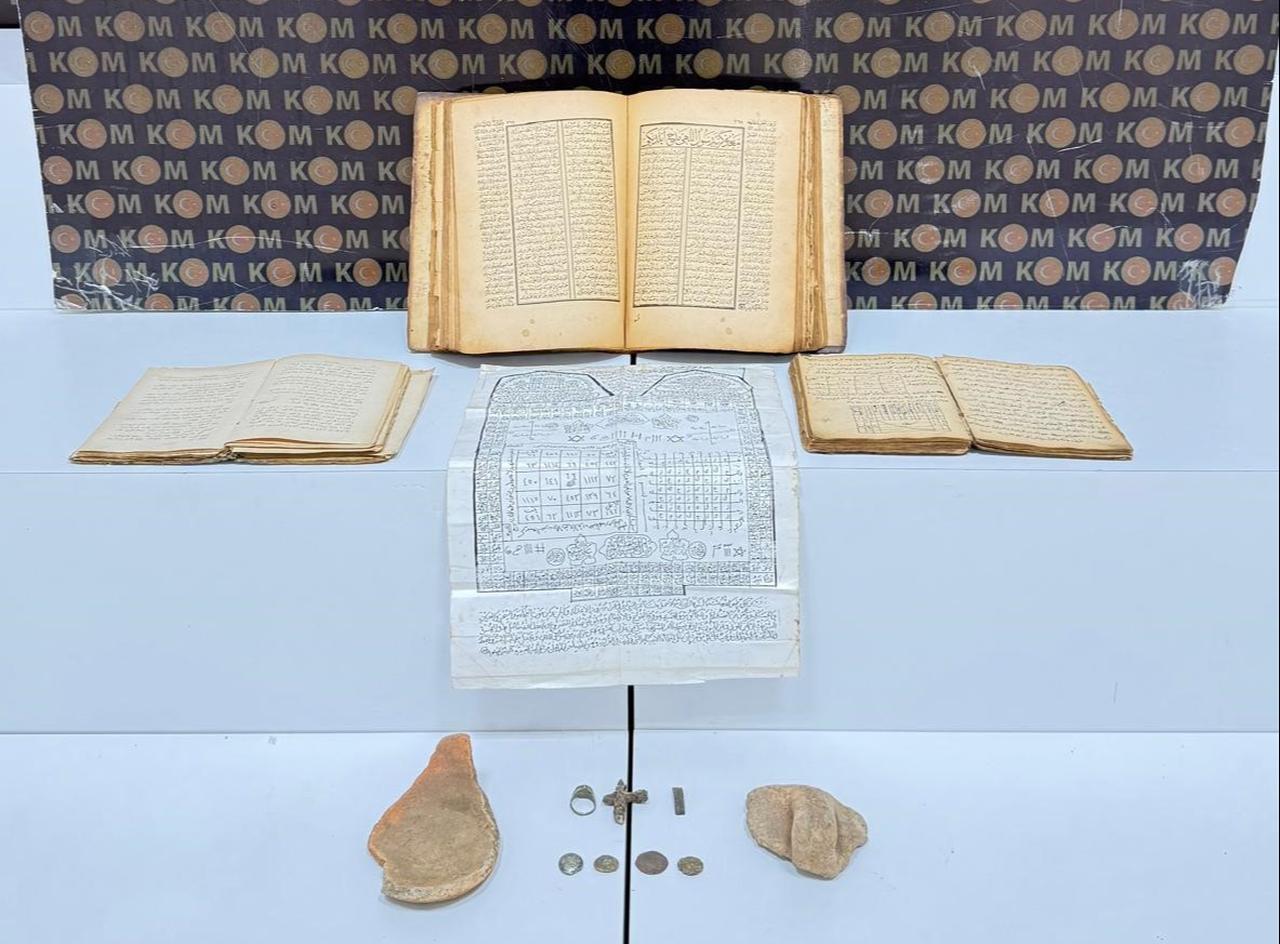 Historical books, a document with Arabic-Hebrew inscriptions, coins, a metal cross and other objects seized during an anti-smuggling operation in Korgan, Ordu, Türkiye, Jan. 13, 2026. (IHA Photo)
