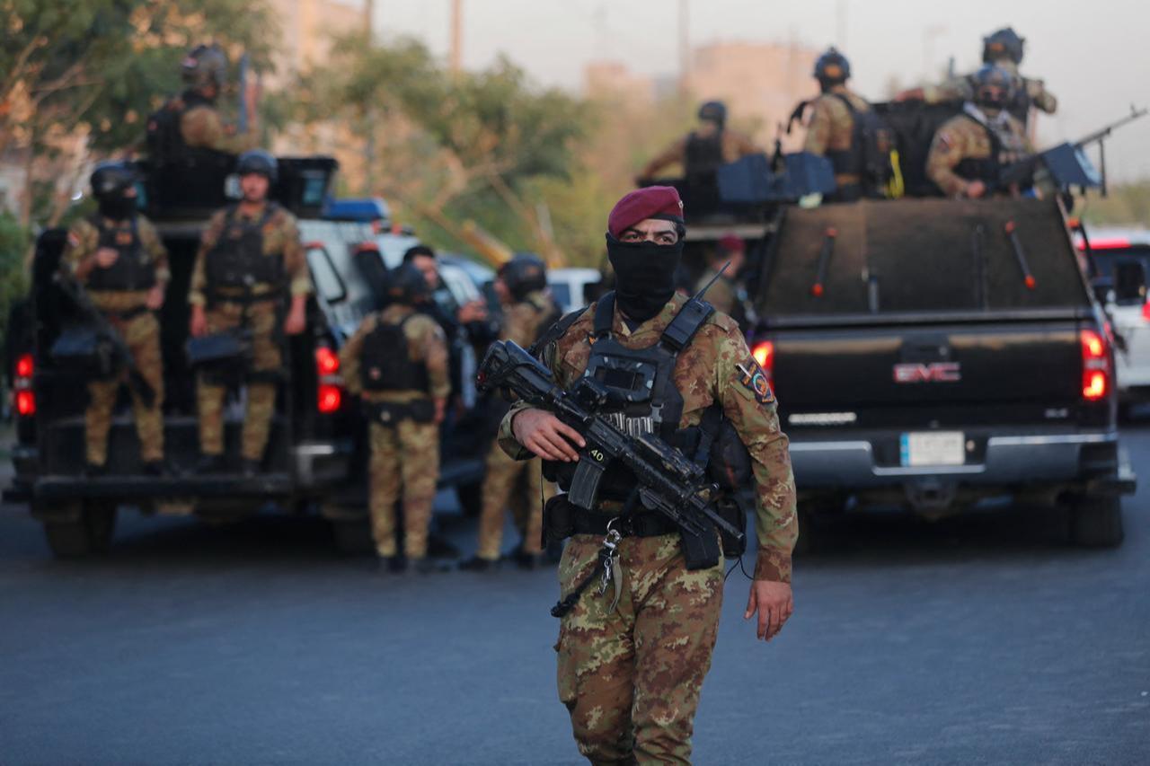 Members of the Popular Mobilization Forces lift flags as they line up during a funeral procession in Baghdad on June 22, 2025. (AFP Photo)