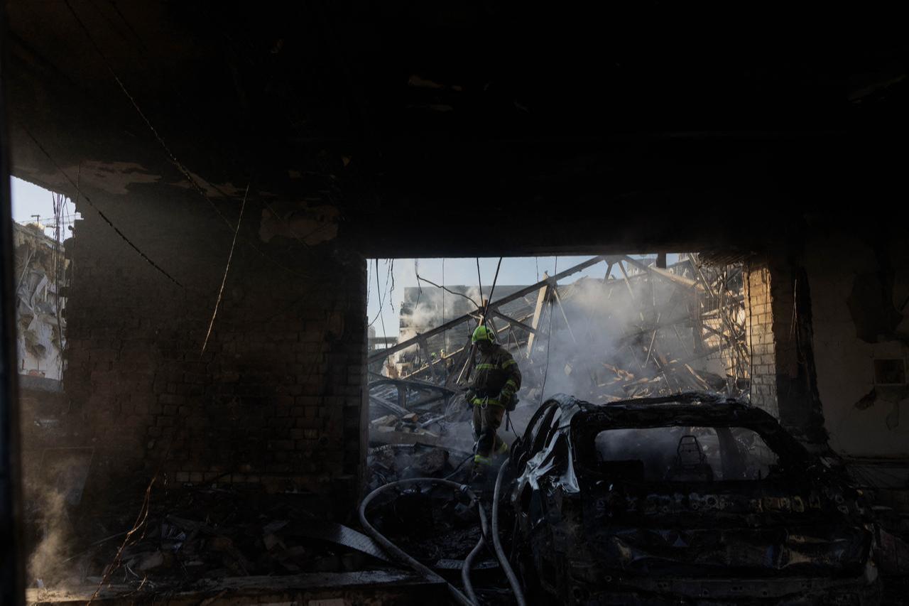 A firefighter walks by a damaged car dealership following massive Russian missile and drone strikes on Kyiv on June 2, 2026. (AFP Photo)