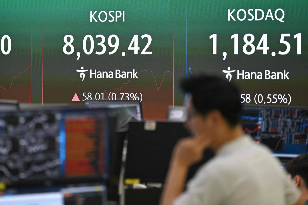 A currency dealer monitors exchange rates as a screen shows South Korea's benchmark stock index (KOSPI) surpassing 8,000 points in a foreign exchange dealing room at the Hana Bank headquarters in Seoul, May 15, 2026. (AFP Photo)