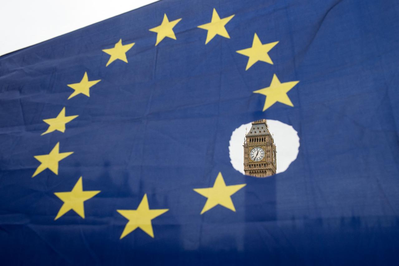 Pro-remain protester holds up an EU flag with one of the stars symbolically cut out. (AFP Photo)
