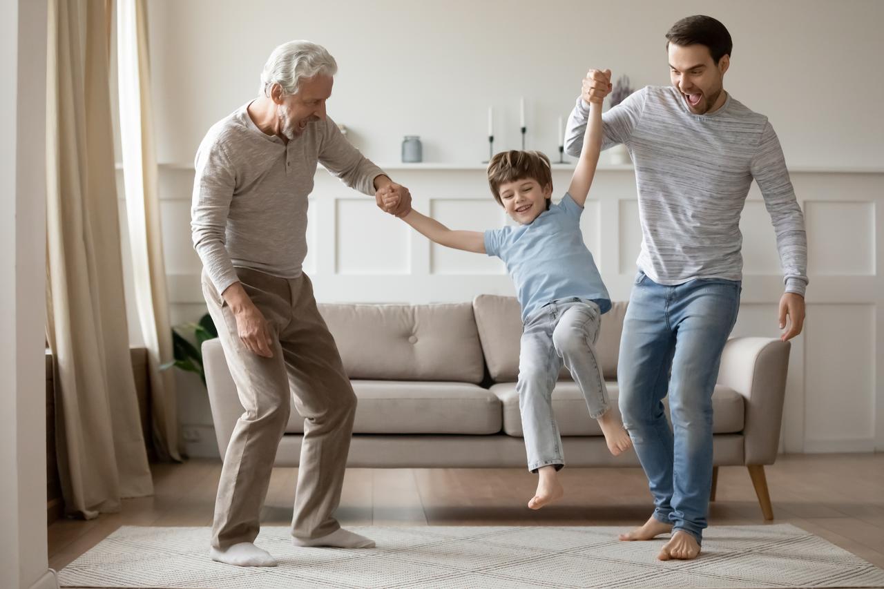 A grandfather and father play with a child at home. (Adobe Stock Photo)