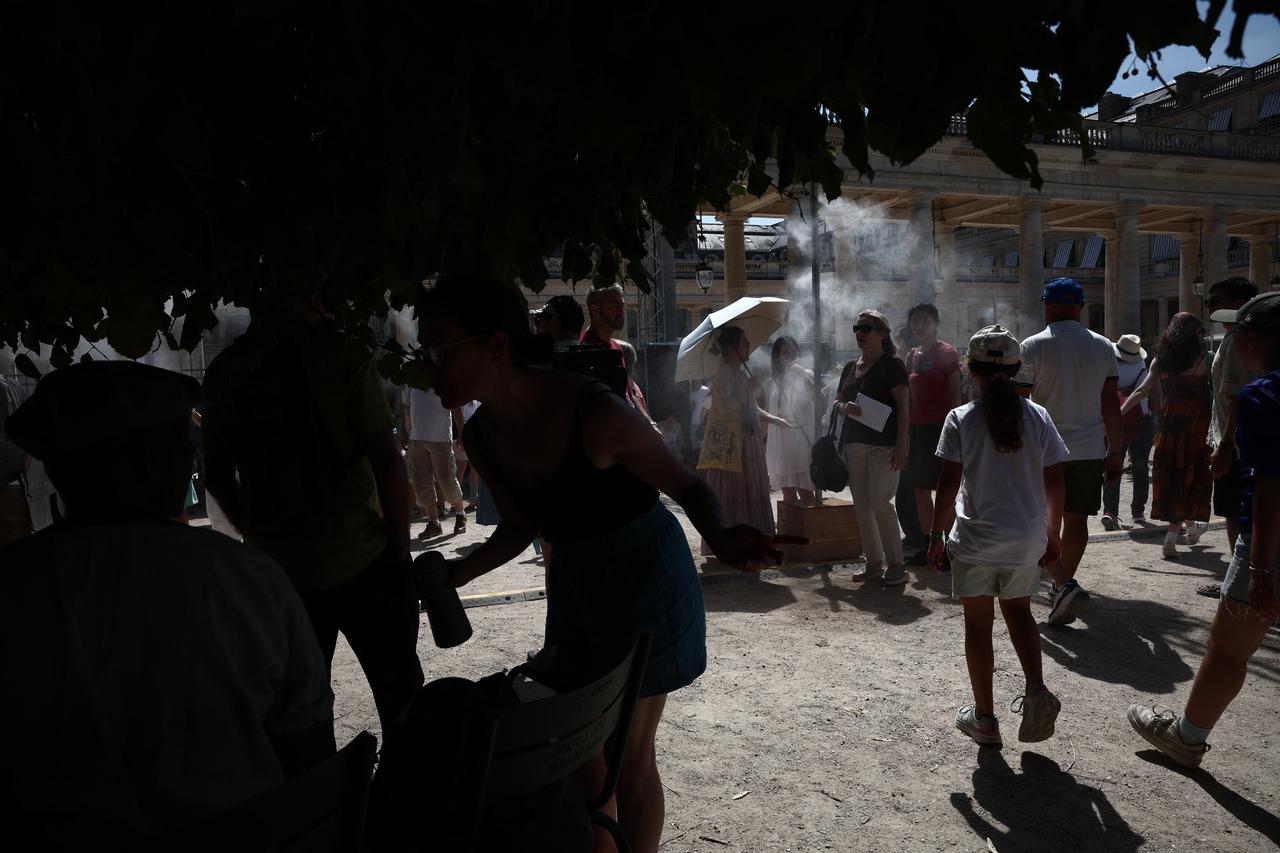 Pedestrians cool off under a mist sprayer installed by Paris City Hall on the 45th edition of the Fete de la Musique (France's national music festival) and during a heatwave in Paris on June 21, 2026. (AFP Photo)