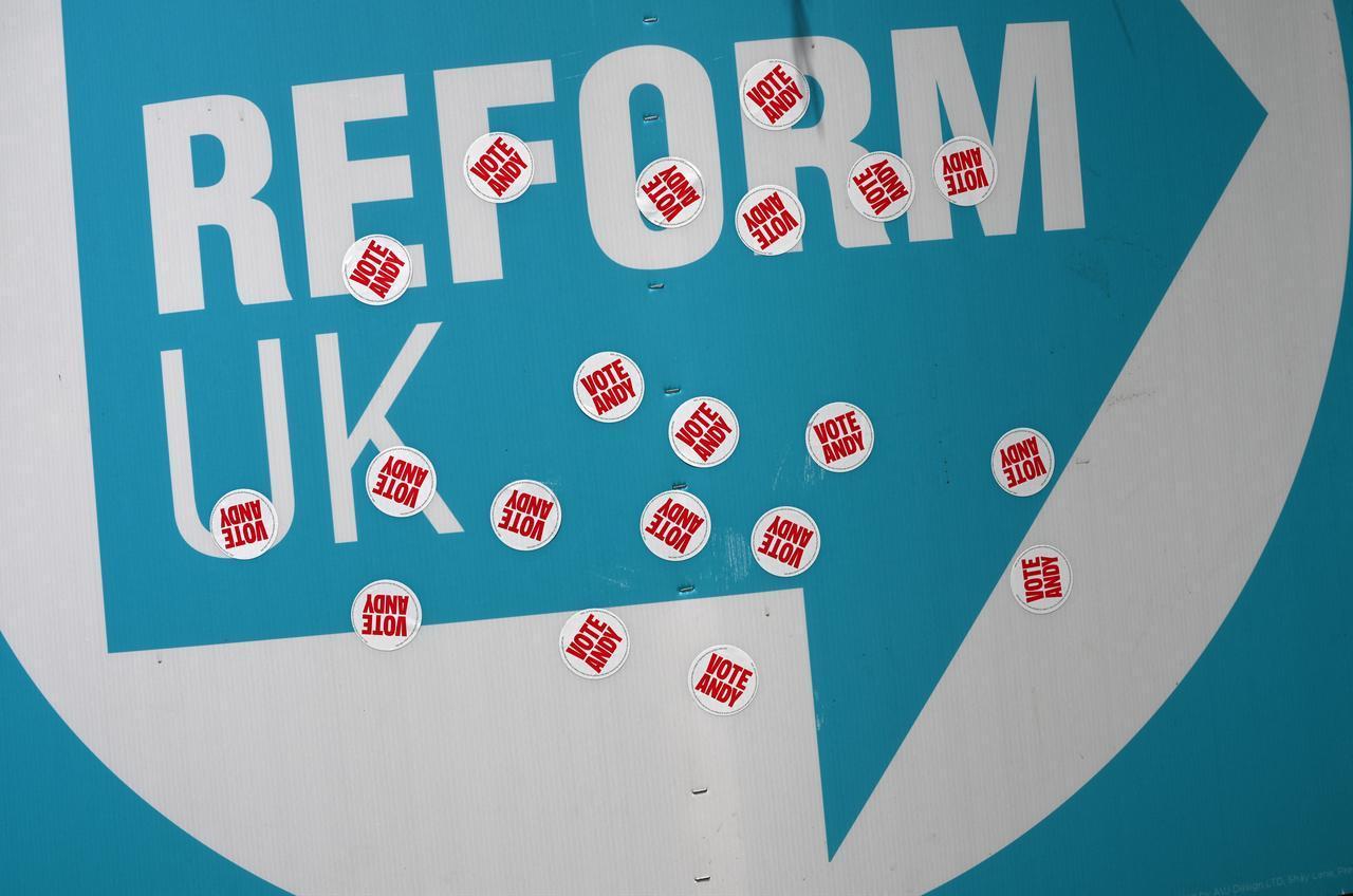 A poster for the Reform UK party, defaced with sticker reading 'Vote Andy' in reference to Labour party candidate Andy Burnhman, is pictured in the garden of a residential property in Makerfield, north-west England, June 16, 2026. (AFP Photo)
