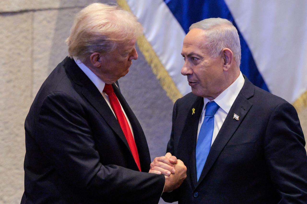 US President Donald Trump (L) holds hands and speaks with Israeli Prime Minister Benjamin Netanyahu at the Israeli parliament, the Knesset, in Jerusalem, Oct. 13, 2025. (AFP Photo)