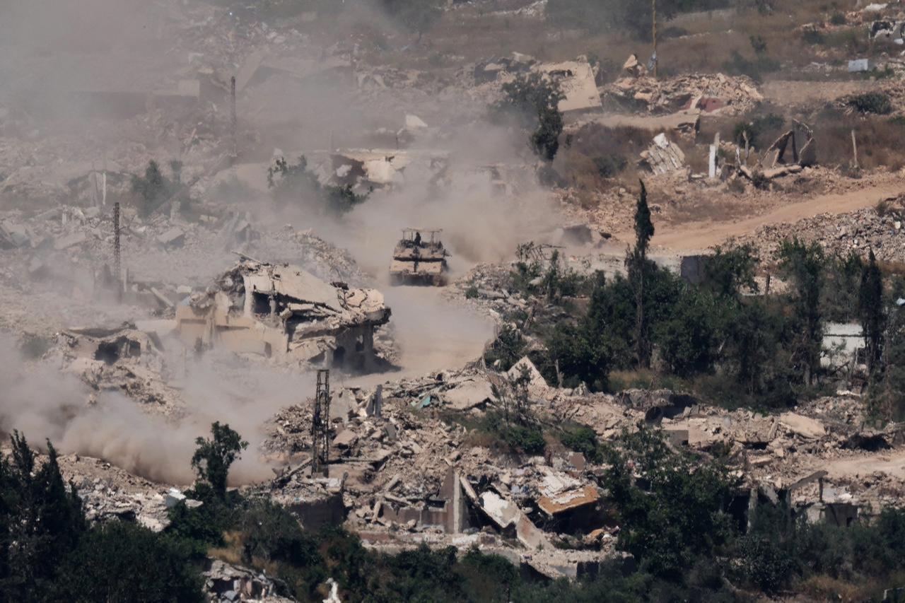 This picture, taken from a position in the Upper Galilee in northern Israel, near the Israel-Lebanon border, shows Israeli Merkava tanks driving along a road past destroyed buildings in southern Lebanon on June 17, 2026. (AFP Photo)