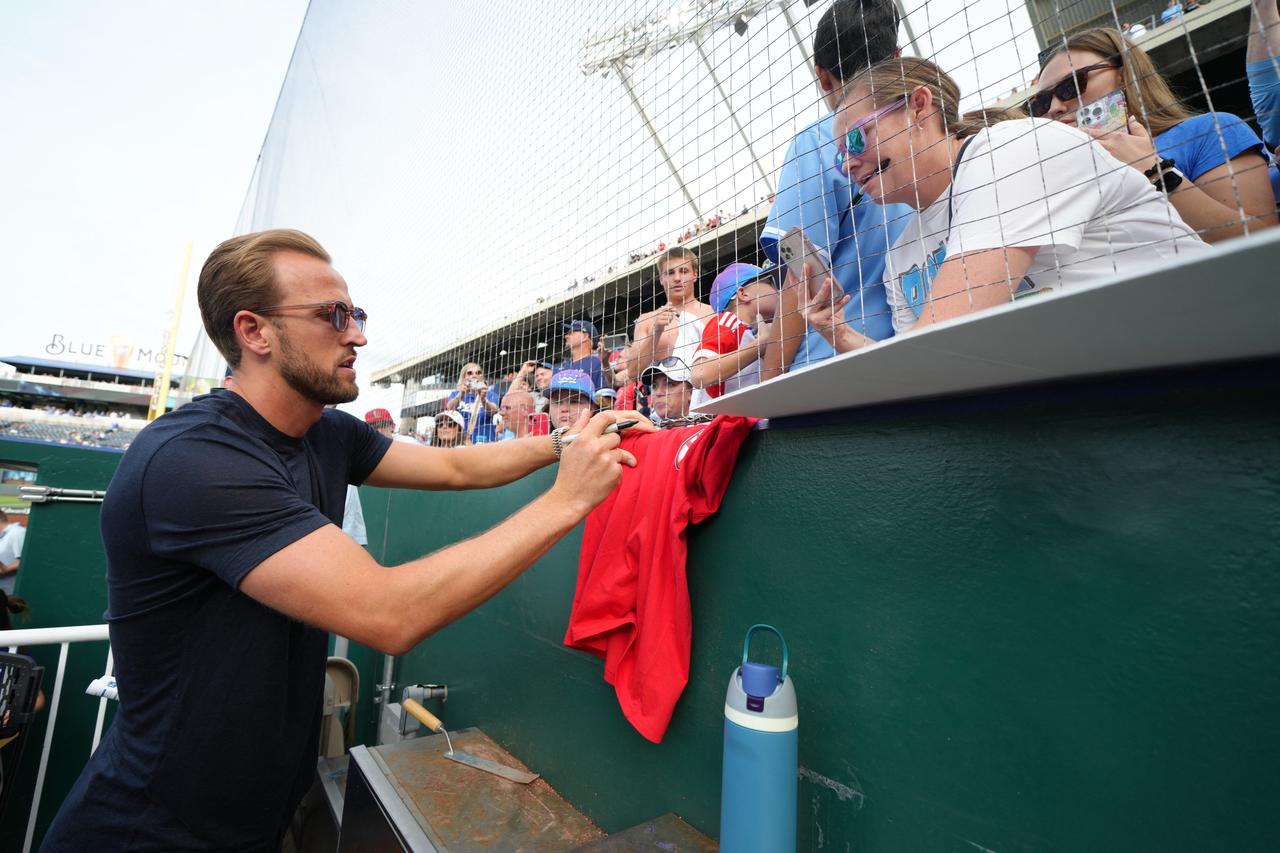 Harry Kane of England signs a fan's shirt as he attends a game between the St. Louis Cardinals and the Kansas City Royals at Kauffman Stadium in Kansas City, Missouri, June 18, 2026. (AFP Photo)