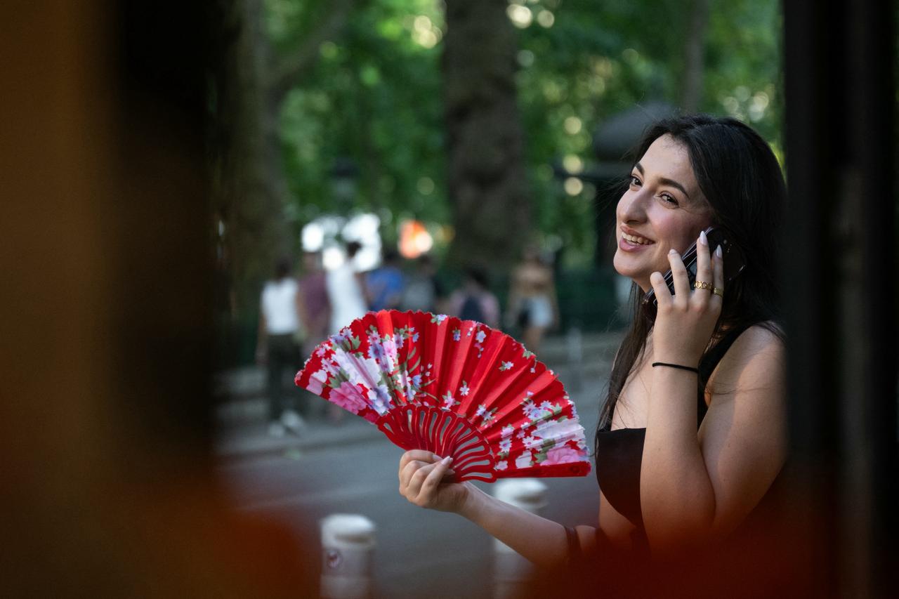 A woman uses a fan to cool off as France experiences a heatwave in Paris, on June 20, 2026. (AFP Photo)