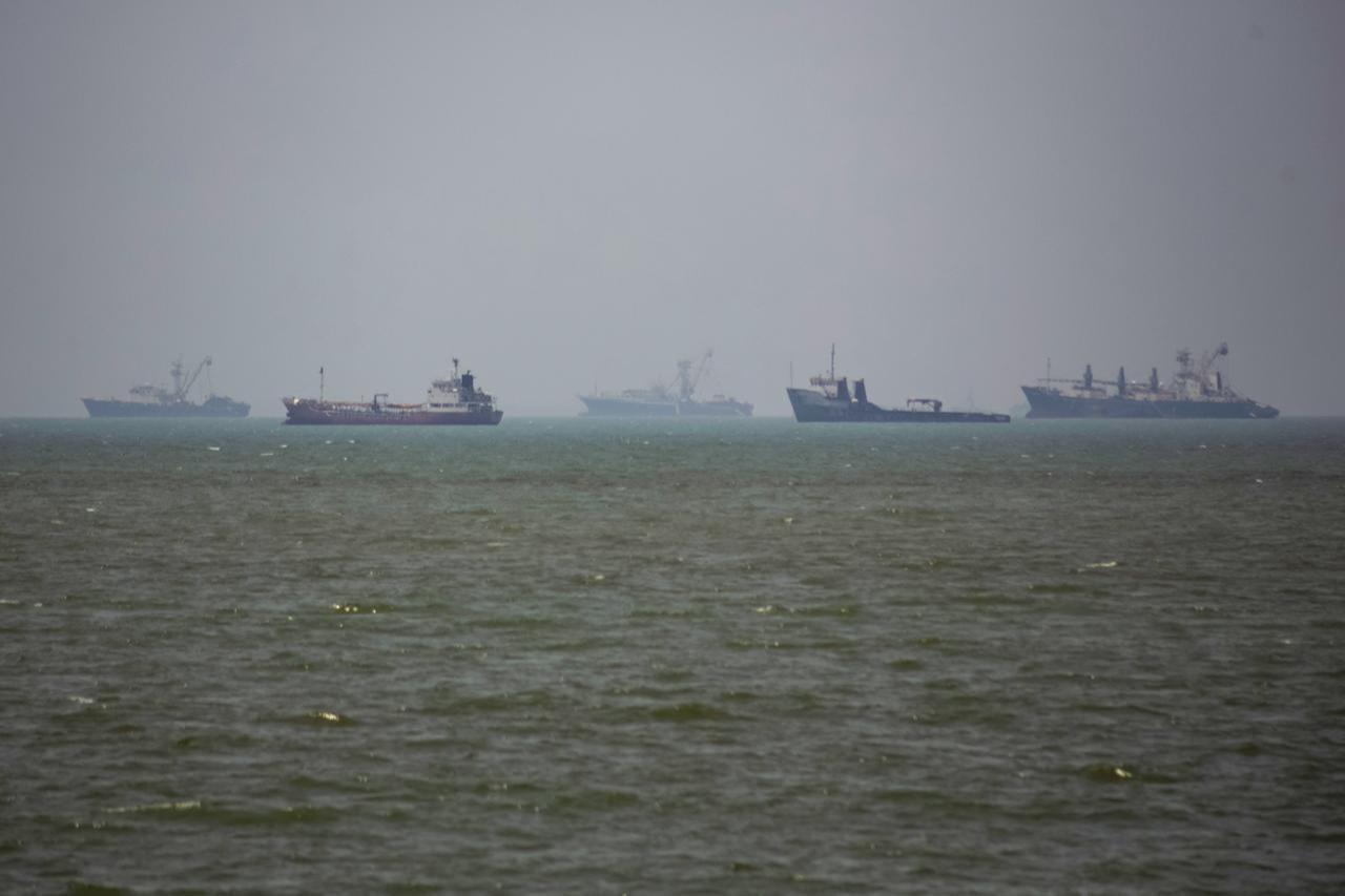 Large commercial vessels and a small boat navigate the waters off the southern port city of Bandar Abbas, Iran, on June 21, 2026. (AA Photo)