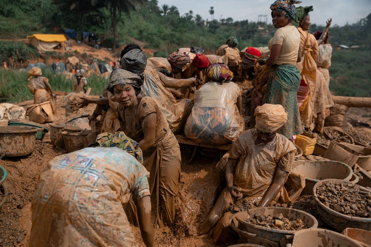 Women miners wearing plastic bags over their clothing, locally known as "decalots", to protect themselves from mud and dirt sort rocks containing gold particles at an artisanal mining site in Mongbwalu, Ituri Province, June 16, 2026. (AFP Photo)