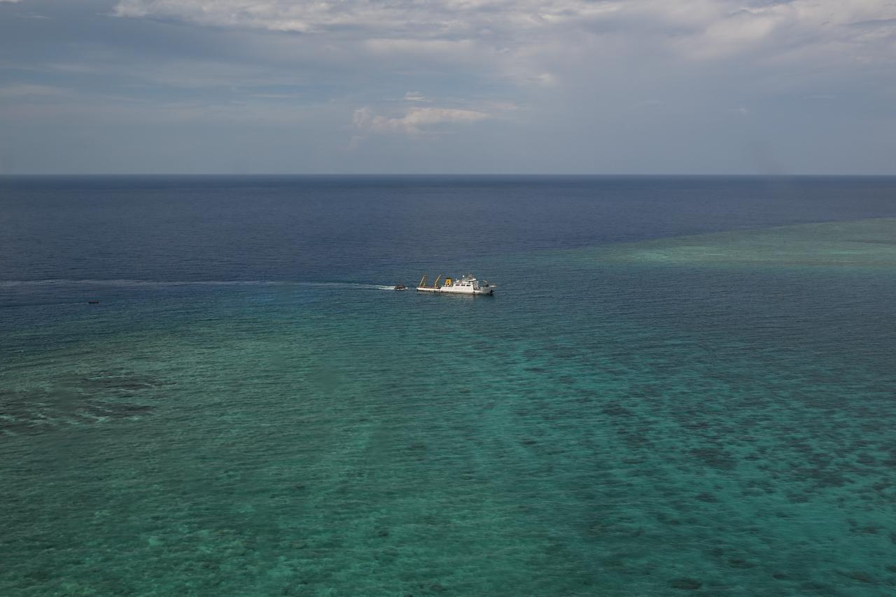 A ship identified by the Philippine Coast Guard as a Chinese research vessel is seen towing a floating structure at the mouth of Scarborough Shoal in the disputed South China Sea, June 15, 2026. (AFP Photo)
