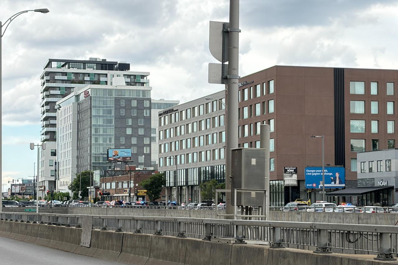 This photo shows a street near the scene of a shooting (next to the tall building at L) in Montreal on June 22, 2026. (AFP Photo)